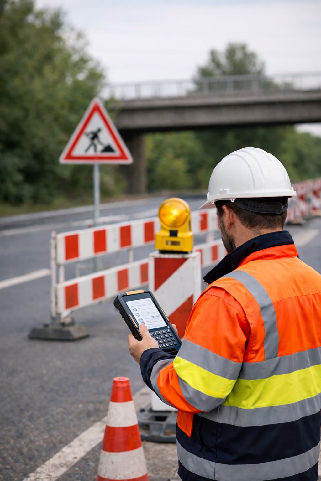 Kontrolle der Verkehrssicherung mit digitalem Erfassungsgerät an einer Baustelle
